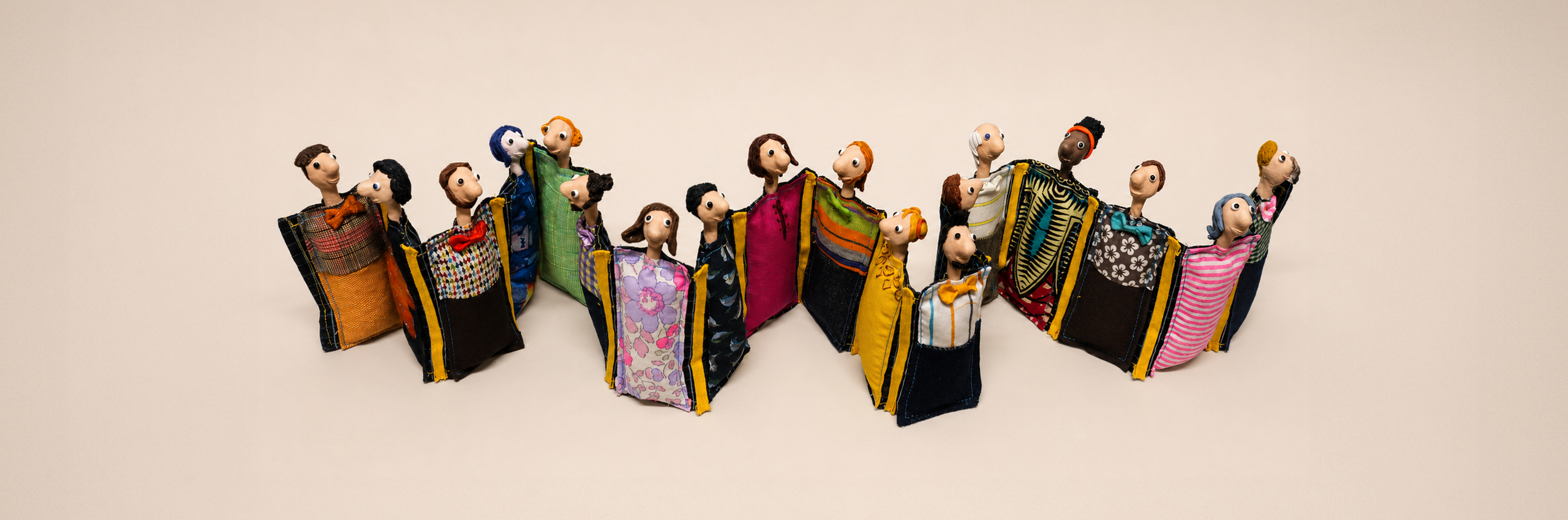 Grupo de personagens artesanais sobre fundo amarelo